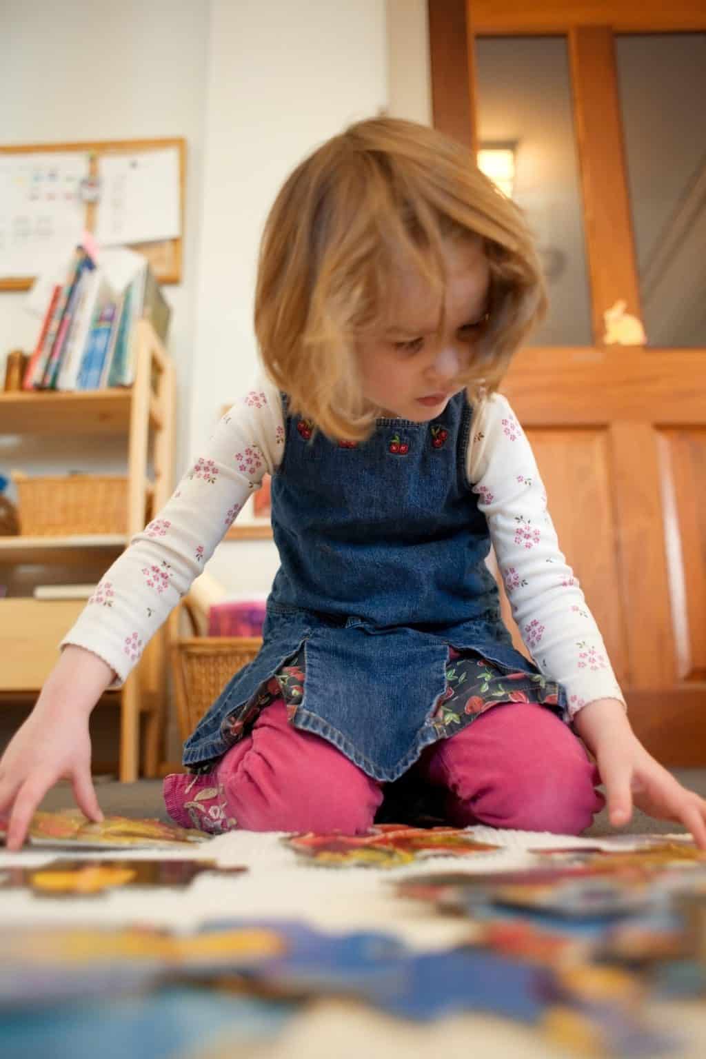 An intent 4-year-old girl in a Montessori classroom